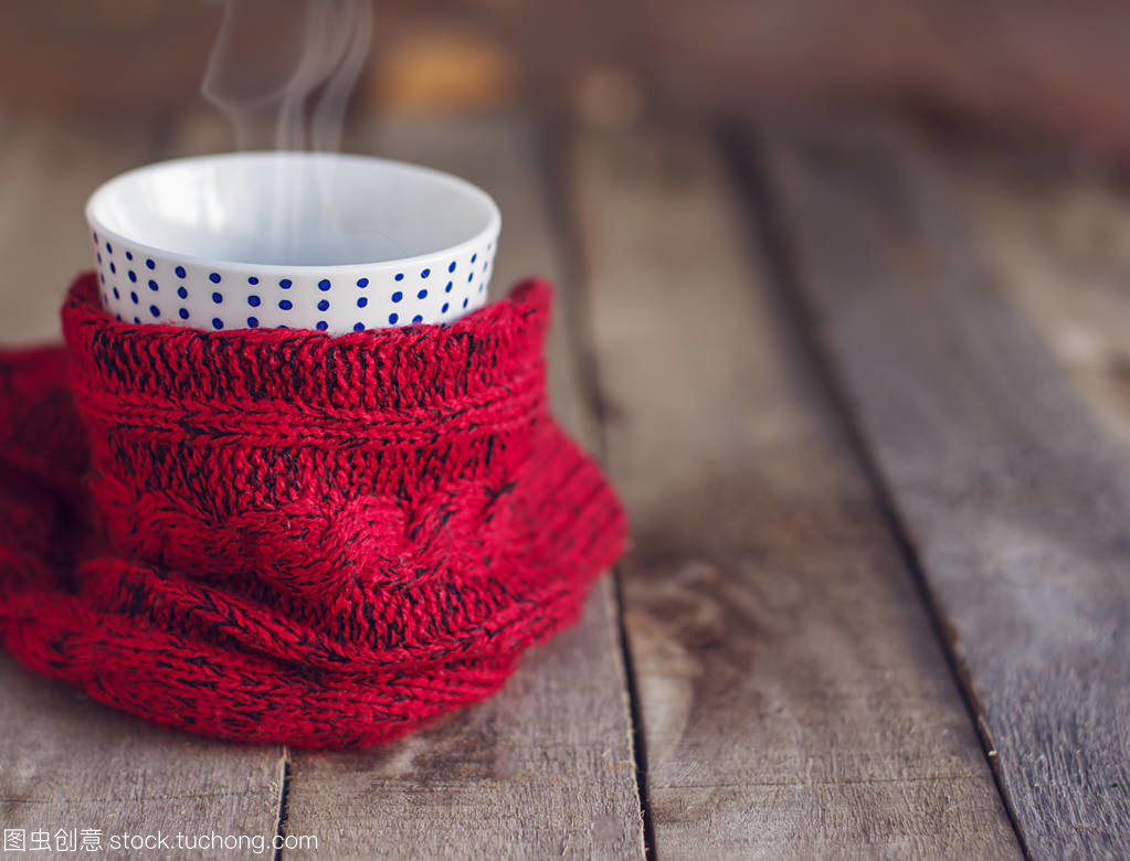 針織圍巾裹著杯熱茶。復制空間